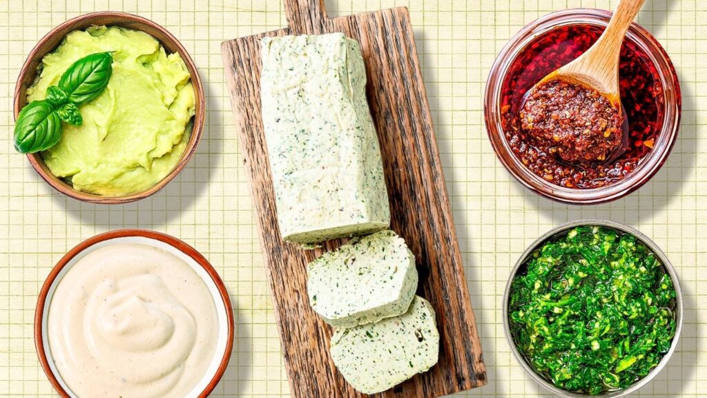 Colorful assortment of dips and spreads: green avocado, creamy tahini, herb-infused butter, spicy condiment, and vibrant salsa
